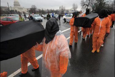 AFP PHOTO /Demonstrators representing prisoners at the US Guantanamo Bay Naval Base walk with a fake casket during a rally against torture sponsored by Witness Against Torture with Amnesty International and the National Religious Campaign Against Torture 11 January, 2008