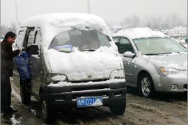 AFPA vehicle stops for a passenger under rare snowfall in Nanjing, 26 January 2008, in eastern Chjna's Jiangsu province. The worst