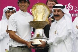 r : Adam Scott of Australia holds the winner's trophy with President of the Qatar Golf Association Hassan Nasser al-Nuaimi (R) at the Qatar Masters Golf tournament in Doha