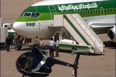 EPA/epa000277498 Iraqi airport staff check an Iraqi Airways aircraft after its first flight from Amman to Baghdad on Saturday, 18 September 2004.