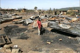 REUTERS/A boy stands within a burnt area in a village near the city of Eldoret February 2, 2008. Youths burned hundreds of homes in a town in Kenya's Rift