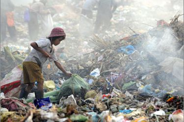 AFP Chek Toy (L) , a 12-year-old Cambodian girl, scavenges to collect recyclable goods at a sprawling, 100-acre garbage dump in Phnom