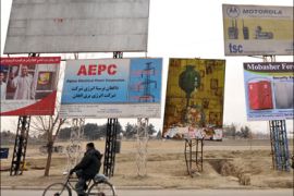 afp - An Afghan man rides his bicycle past by a roadside billboard (C) warning on the dangers of opium consumption and reading 'poppy cultivators are criminals who bring