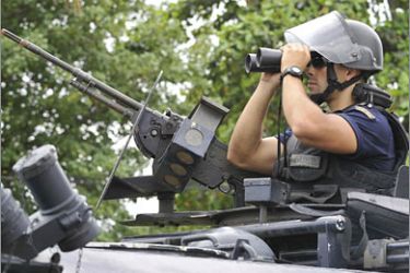 AFPUN peace keeping troops are seen providing security near the house of fugitive military leader Alfredo Reinado before the funeral on February
