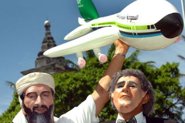 A reveller fancy dressed as Osama Bin Laden (L) holds an inflatable toy plane next to another reveller dressed as US president George W. Bush during the Galo da Madrugada