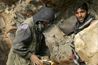 In this photograph taken May 27, 2007 Afghan miners drill into rock in a makeshift emerald mine in The Panjshir Valley. Afghanistan is sitting on a gold mine of mineral reserves -- perhaps the richest in the region