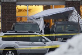 REUTERS/Officials remove the remains of a shooting victim in Tinley Park, Illinois where five people were shot and killed in a lane Bryant Store,