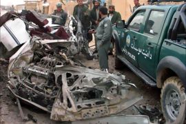 Police inspect the wreckage of a police car which was hit by a roadside bomb in Lashkar Gah February 21, 2008. At least two policemen were killed and four others wounded after