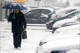 . AFP / A man walks under snowfall in Wuhan, 01 February 2008, in central China's Hubei province. China's gridlocked transport system rumbled back to life but millions of angry travellers