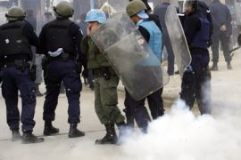 U.N. riot police react to a thunderflash thrown by Serb protesters on the main bridge in the ethnically divided town of Mitrovica in Kosovo February 22, 2008. Several thousand