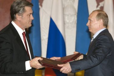 Russia's President Vladimir Putin (R) and his Ukraine's counterpart Viktor Yushchenko exchange documents as they meet in Moscow's Kremlin