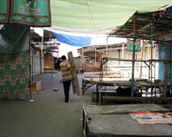 مواطن يمر بمحلات مغلقة في حي العمل ببغداد أمس (الفرنسية) 