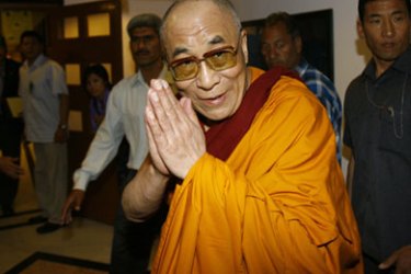 Tibetan spiritual leader His Holiness the Dalai Lama presses his palms together in greeting as he arrives for a prayer teachings in New Delhi