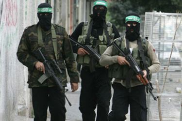Masked Palestinian Hamas militants arrive to a press briefing in Gaza City