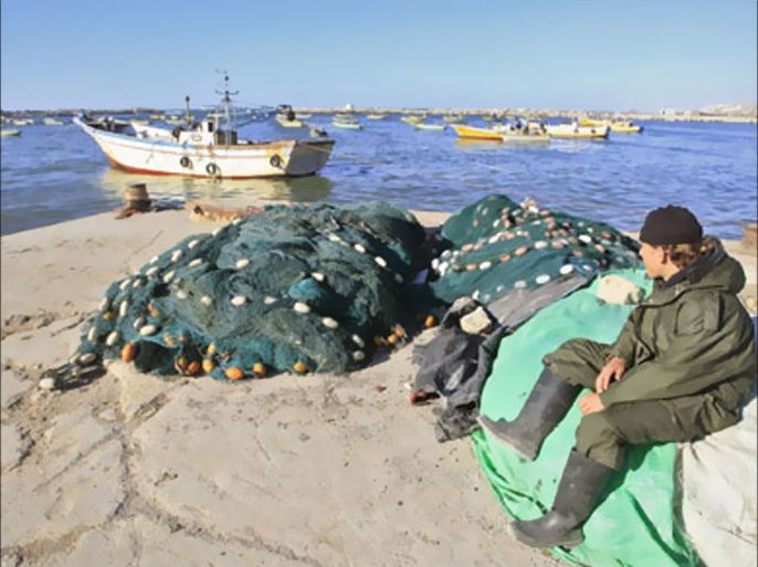 Eighteen-year-old Palestinian fisherman, Khalil Baker, sits on fishing nets at the port of Gaza City on March 15, 2008. The border closure imposed in a bid to halt almost daily rocket fire by Gaza militants on southern Israel has left much of the fishing fleet in the impoverished Palestinian enclave lying idle at the watersid