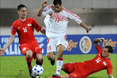 f_Lebanese player Mohamad Ghaddar (C) is tackled by Singapore's Daniel Bennet (L) and John Wilkinson (R) during their World Cup qualifier match in Singapore