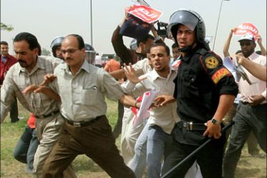 afp : Egyptian supporters of the Muslim Brotherhood run past a riot policeman during scuffles outside a military court in northeastern Cairo on April 15, 2008. Egyptian police