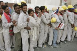 Foreign workers stand in line to take a bus that will transport them to where they live at the end of their shift at a construction site in Dubai on April 16, 2008.