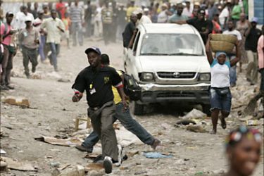 r_Residents run as inspectors arrive in a car to seize belongings during a campaign to relocated at least 9,000 street market sellers to a new fixed market location