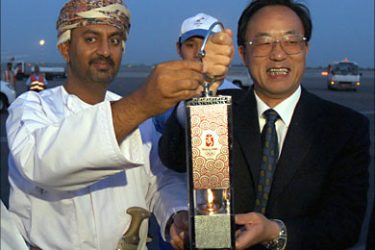f_Omanian sport minister Ali Bin Massoud Bin Ali Al-Sunaidi (L) and executive member of the Olympic Organizing Committee, Liu Ging Min (R) hold the lantern carrying