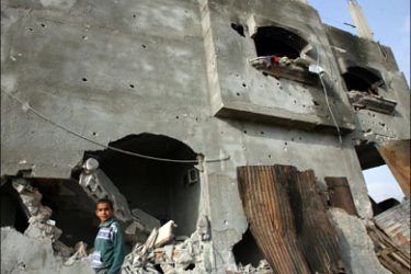 afp - A Palestinian boy walks past a damaged house following a raid in Beit Lahia in the northern Gaza Strip on April 26, 2008. A teenager was killed and eight other people
