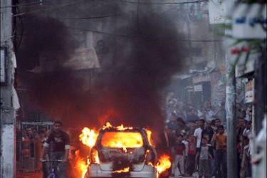 afp - People gather at the scene of a shooting attack at the Balata refugee camp in the West Bank city of Nablus on April 13, 2008. Three people were wounded and a car cought fire
