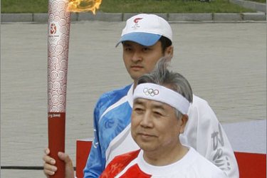 REUTERS/Kim Jung-gil, president of South Korea's Olympic Committee and also the first bearer of torch relay in South Korea, runs with the torch at the Seoul