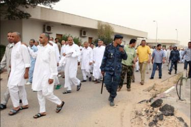 afp : Escorted by security, Prisoners are released from a jail in the Libyan capital Tripoli on April 8 2008. Libya has freed 90 members of the Libyan Islamic Fighting Group, an