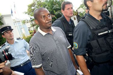 Policeman escort ousted leader of the Comoros island of Anjouan, Mohamed Bacar (C) upon his arrival at the Administrative court on April 6, 2008 in Saint-Denis de la Reunion. Bacar was held in custody with 22 other people ton the French island of Reunion because of an extradition request by Comoran authorities, prosecutors said.
