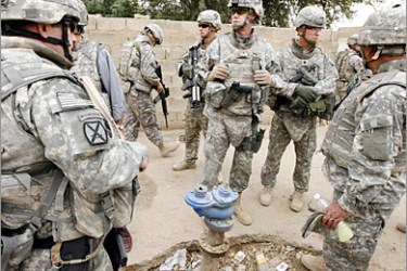 REUTERS /U.S. soldiers gather near a fire hydrant that they are planning to replace with a water pipe for a new water plant project in New Baghdad district April 30, 2008. Iraq's services -- its