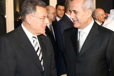 Lebanon's newly elected President Michel Sleiman (R) speaks with outgoing prime minister Fuad Siniora as they arrive for an official dinner at Biel centre in Beirut