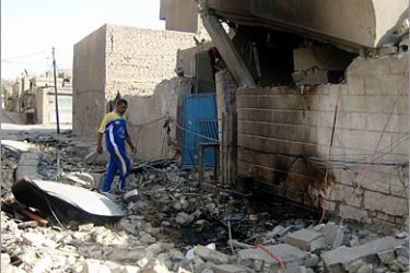 AFP / An Iraqi walks past the debris of a building in the Shiite Muslim Sadr City district of Baghdad on May 05 2008. At least 10 people were killed in overnight fighting between