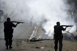 Policemen take aim during clashes believed to be linked to recent anti-foreigner violence in Zandsfontein informal settlement outside Johannesburg, May 18, 2008. Hundreds of foreigners living in South Africa took refuge in police stations and churches as week-old violence against them spread further across poor townships, local media reported on Sunday.