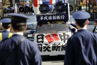 Police officers block rightest group campaign cars while protesting against the visit of Chinese President Hu Jintao in Tokyo on May 6, 2008