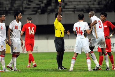 AFP Bahrain's defender Abduula A. Rahman Marzooqi (2nd R in white jersey) argues with Malaysian referee Mohd Nafeez (C), flashing the yellow