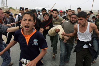 AFP/ Palestinians protestors carry a boy who was wounded by Israeli military gunfire during a "Nakba" rally at the Erez crossing with Israeli in the northern Gaza Strip on May 15, 2008.