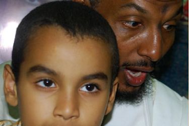 Mohammed al-Haj (L) sits on the lap of his father Sami al-Haj, Sudanese cameraman of Arab satellite news channel Al-Jazeera, in al-Amal Hospital in Khartoum on May 2, 2008. Haj accused today US authorities of insulting Islamic symbols on his return home after six years of detention