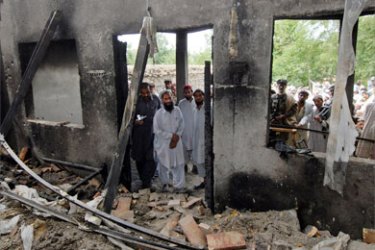 Pakistani alleged Taliban supporters and residents watch a house said to have been destroyed by a US missile strike in Damadola village in the northwestern Bajaur tribal district which borders Afghanistan's volatile Kunar province, on May 15, 2008.