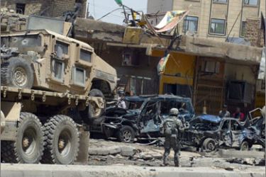A US soldiers guard a wrecked US army HUMVEE being pulled out from the scene of a car bomb attack in Baghdad on May 01, 2008
