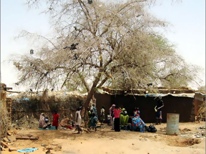 REUTERS/ Residents sit under a tree to avoid the hot sun at Zam Zam camp in Sudan's North Darfur state June 8, 2008. Just 10 km (6 miles) from El Fasher's colourful market stalls, thousands
