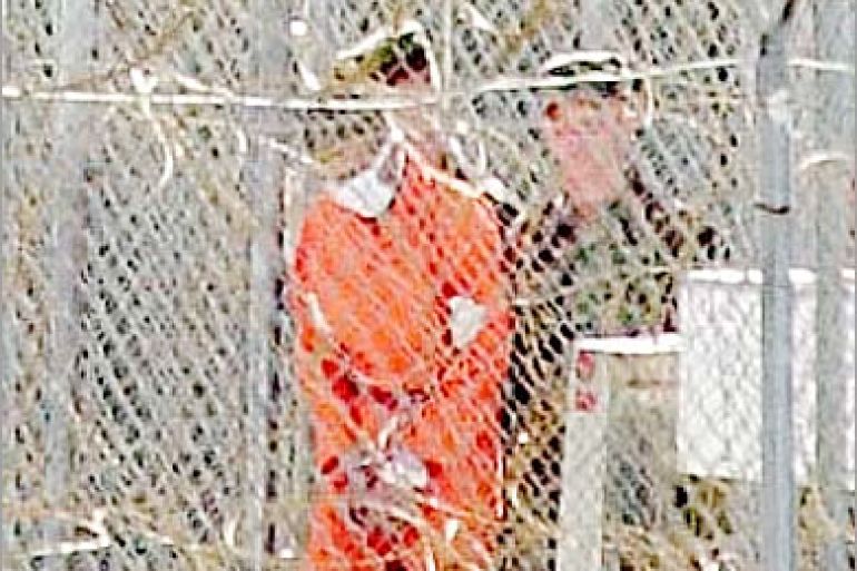 AFP (FILES)A detainee is handled by Army soldiers at Camp X-Ray where 110 Al-Qaeda and Taliban detainees are being currently held by US authorities at the US Guantanamo US