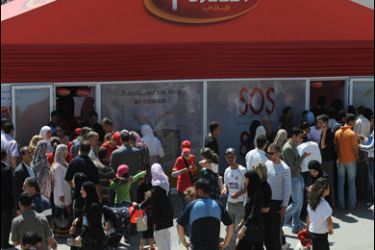 AFP PHOTO/Algerian customers queue at the entrance of a "Djezzy Telecom" office during the 40th Algerian International Exhibition (SAFEX) on June 12, 2008 in Algiers.