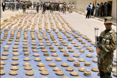 F/Iraqi security forces stand by captured landmines laid out in rows in a street in the southern city of Amara in Maysan province, 365 kilometres south of Baghdad, on June 18, 2008. Dozens of Shiite militiamen surrendered to Iraqi forces today, hours before the expiry of a deadline set by Prime Minister Nuri al-Maliki for them to lay down their arms ahead of a new crackdown in the south of the country. AFP PHOTO/ESSAM AL-SUDANI