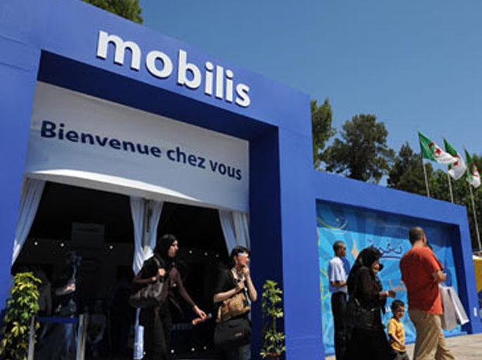 AFP PHOTO/Algerian customers walk out of a Mobilis Telecom office during the 40th Algerian International Exhibition (SAFEX) on June 12, 2008 in Algiers.
