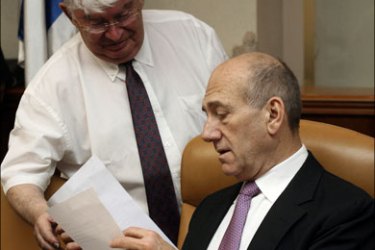 afp : Israeli Prime Minister Ehud Olmert looks at documents at the start of the weekly cabinet meeting at his Jerusalem office on July 20, 2008. Olmert's lawyers today kept up