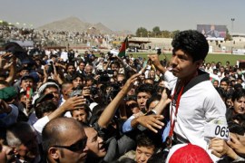 Afghan Olympic taekwondo bronze medallist Rohullah Nikpai is carried by the crowd during a procession for his homecoming in Kabul from the Beijing 2008 Olympic games