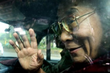Tibetan spiritual leader the Dalai Lama waves from inside a car as he enters the Leelavati hospital in Mumbai on August 28, 2008. The 73-year-old monk is in the city for a medical