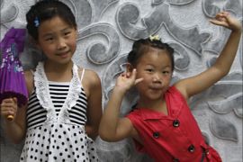 r_Girls pose in front of a sculpture in the subway under Tiananmen Square ahead of the Beijing 2008 Olympic Games August 3, 2008. REUTERS/Gil Cohen Magen (CHINA)