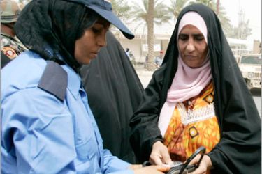 REUTERS/ A policewoman checks the identification papers of a woman before she sees Diyala's governor who is meeting displaced families in Baquba, 65 km (40 miles) northeast of Baghdad,