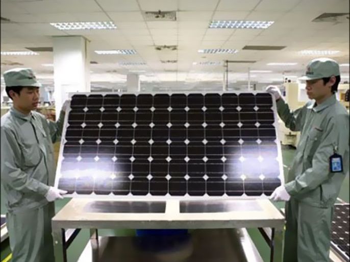 r : Workers hold a panel of solar cells on the production line at a Suntech Power Holdings plant in this undated handout photo. Suntech Power Holdings is set to release its quaterly